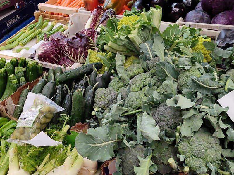 Broccoli, courgettes and radicchio piled on a market stall