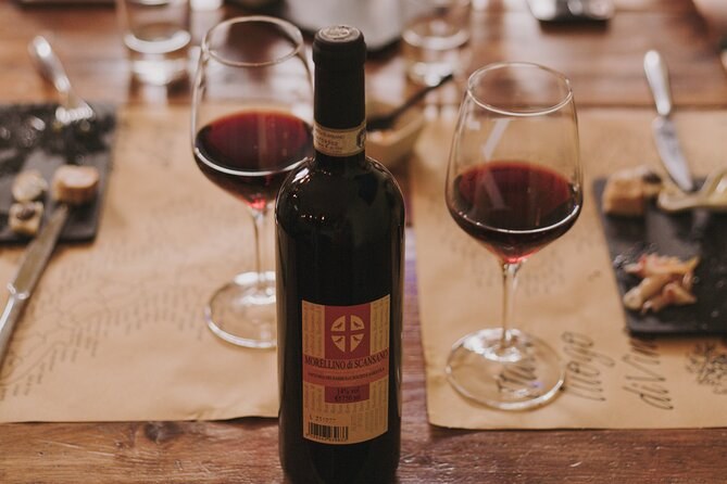 Two glasses of red wine and the bottle on a tasting table